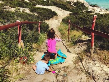 Rear view of siblings playing at beach