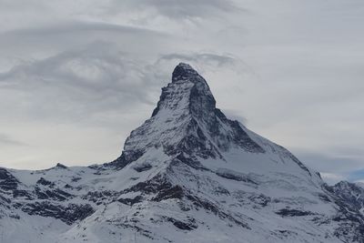 Scenic view of snowcapped mountain against cloudy sky