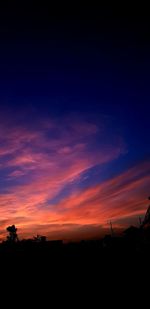 Silhouette landscape against dramatic sky during sunset