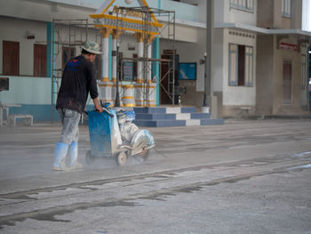 Rear view of man walking on street against buildings