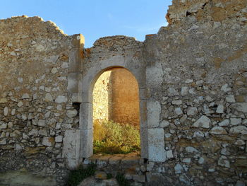 Stone wall of old building against sky