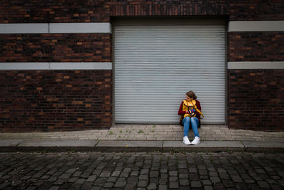 Woman standing on brick wall