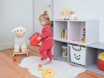 Girl playing with toys in the white children's room