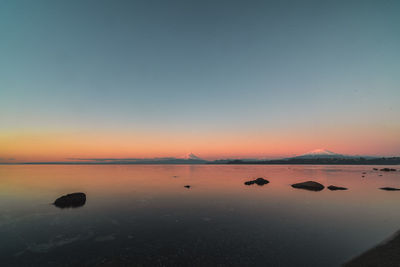 Scenic view of sea against clear sky during sunset