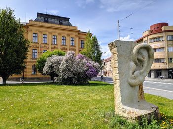 Statue by building against sky in city