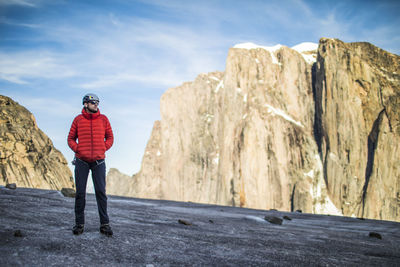 Rear view of man standing on mountain against sky