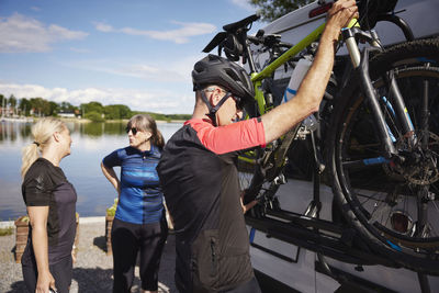 Man taking bicycle off van rack