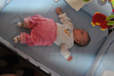 High angle view of baby lying in crib at home