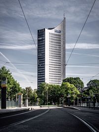 Street by buildings against sky in city