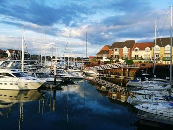 Sailboats moored at harbor