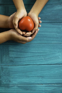 Cropped hands of person holding bell pepper on table