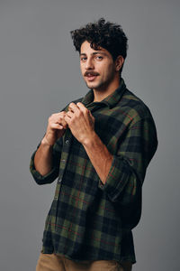 Portrait of young man standing against white background