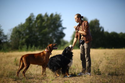 Man with dog standing on field