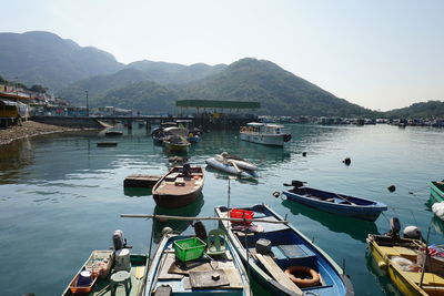 Boats moored in harbor against clear sky