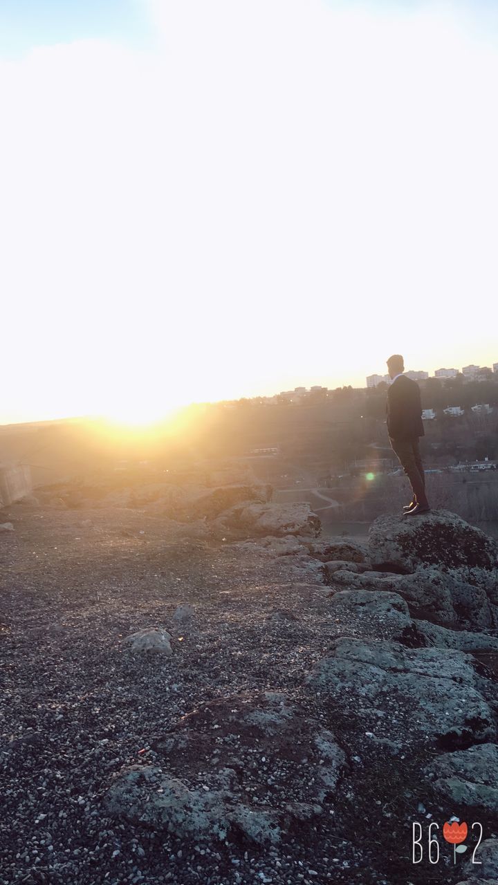 MAN STANDING ON SNOW COVERED LANDSCAPE AGAINST CLEAR SKY