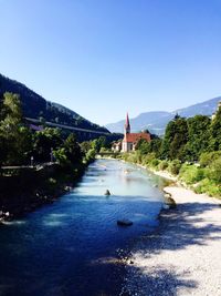 Bridge over river against clear blue sky