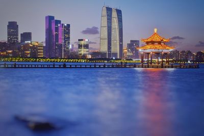 Illuminated buildings in city at dusk