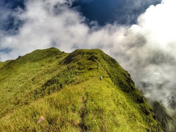 Low angle view of green mountain against sky