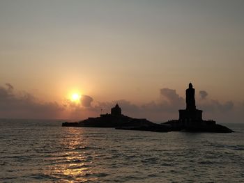 Silhouette ship in sea against sky during sunset