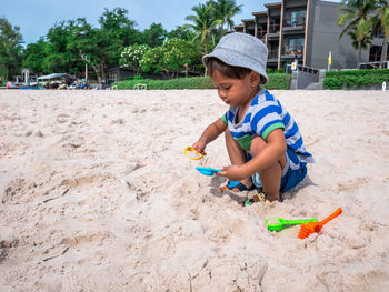 Boy playing with toy on sandy beach