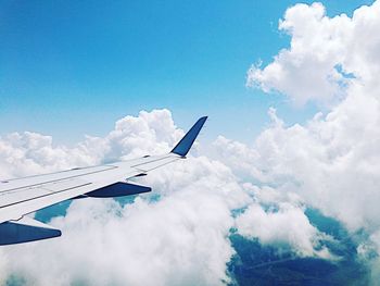 Airplane wing against cloudy sky