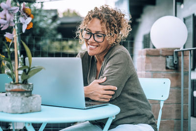 Portrait of young woman using laptop at office