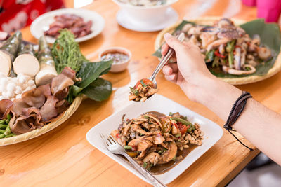 Cropped hand of having food at table