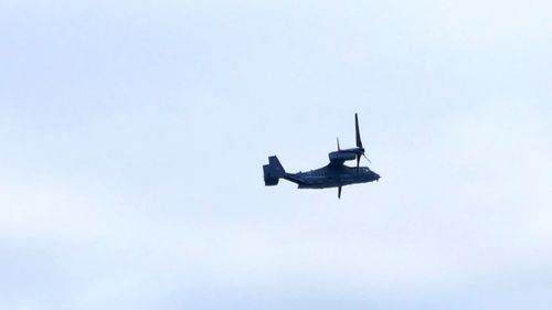 Low angle view of helicopter flying in sky