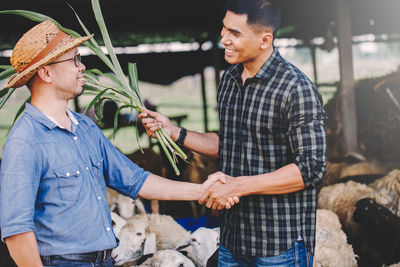 Financial advisor shaking hand with farmer at farm