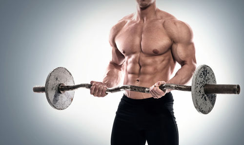 Shirtless man exercising in gym