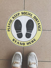 Low section of man standing on tiled floor