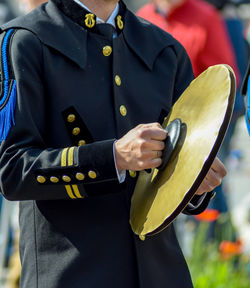 Midsection of man holding cymbals