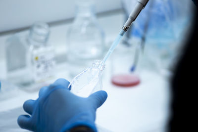 Midsection of scientist examining chemical in laboratory