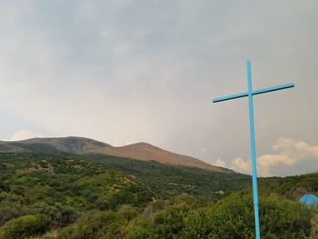 Cross on landscape against sky