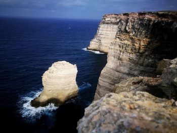 Rock formation in sea against sky