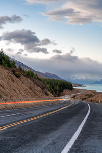 Mount cook road alongside lake pukaki with snow capped southern alps in winter evening light. 