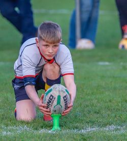 Boy playing with ball on grass