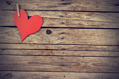 High angle view of red heart shape on wooden table