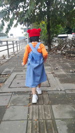 Rear view of girl standing on footpath