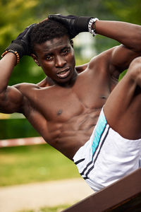 Low section of shirtless man exercising in park