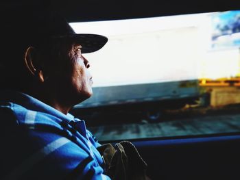 Man looking through window while sitting in vehicle