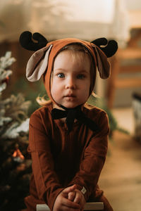 Portrait of toddler baby girl in rudolph reindeer costume. christmas concept christmas tree