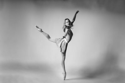 Ballet dancing against gray background