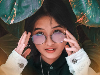 Portrait of woman wearing eyeglasses against plants