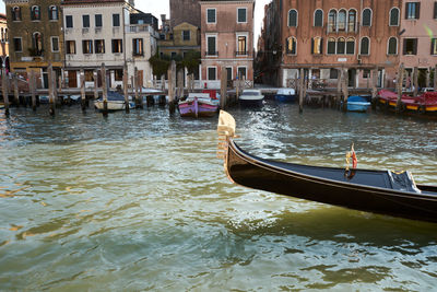 Boats in canal by buildings in city