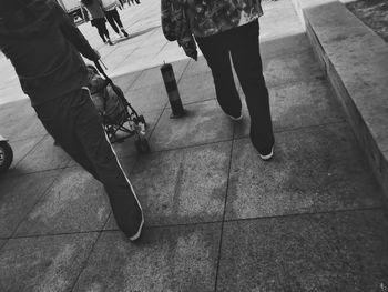 Low section of people walking on tiled floor