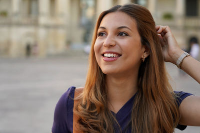 Portrait of smiling young woman in city