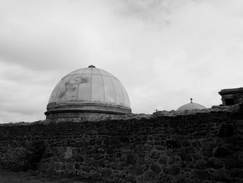 Low angle view of roof and surrounding wall against sky