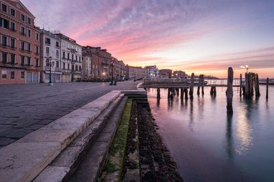 Sunset over river with buildings in background