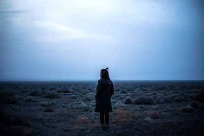 Rear view of woman standing on land